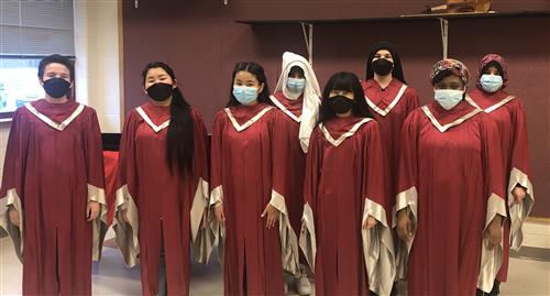 Photo shows eight members of the "Signing Ambassadors" of East Middle School dressed in red vintage choir robes.